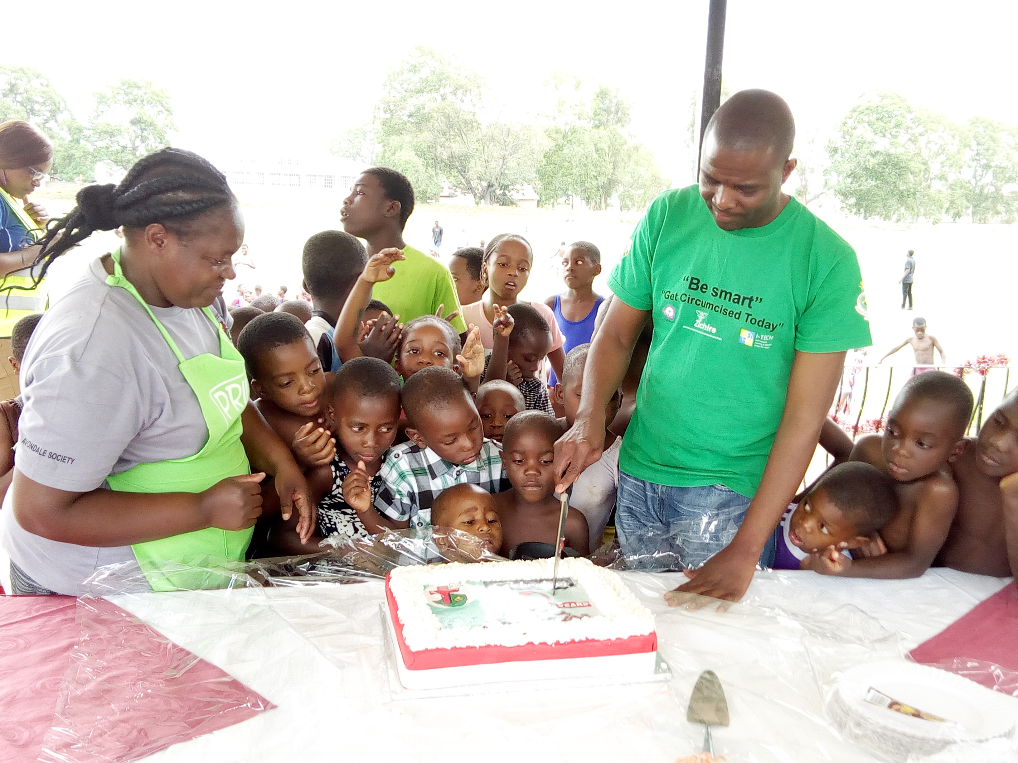Small children gather for the treat of a piece of celebration cake