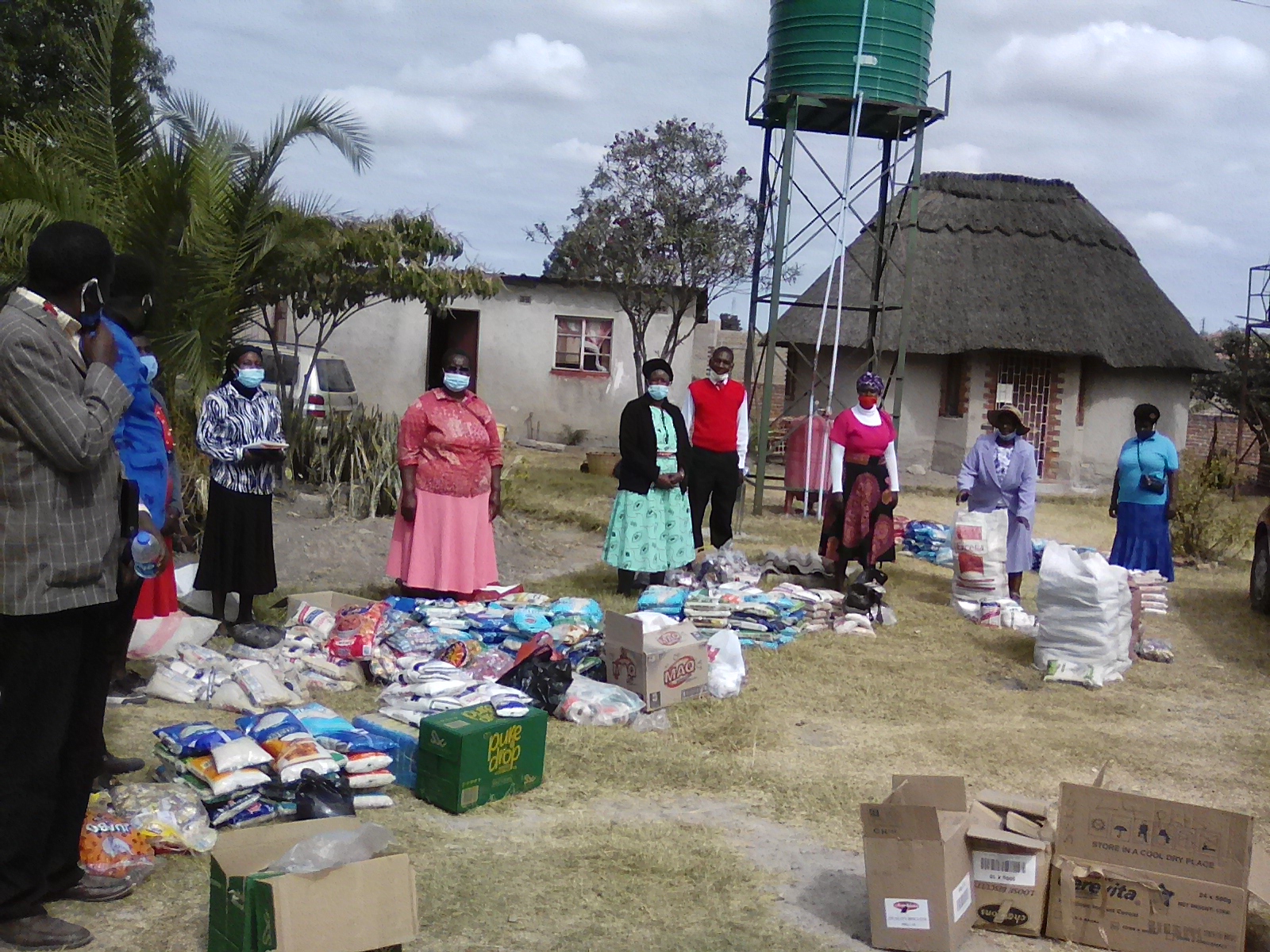 Fully masked, staff collect donations from a church in Harare